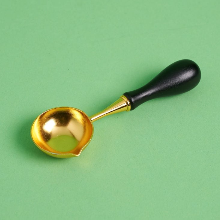 gold and black wax melting spoon