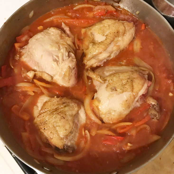 chicekn, sliced onions and peppers sauteing in pan with crushed tomatoes