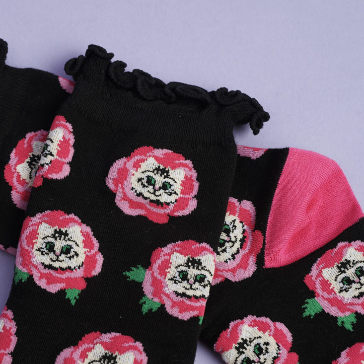 close up of pink and black cat socks with ruffle cuff