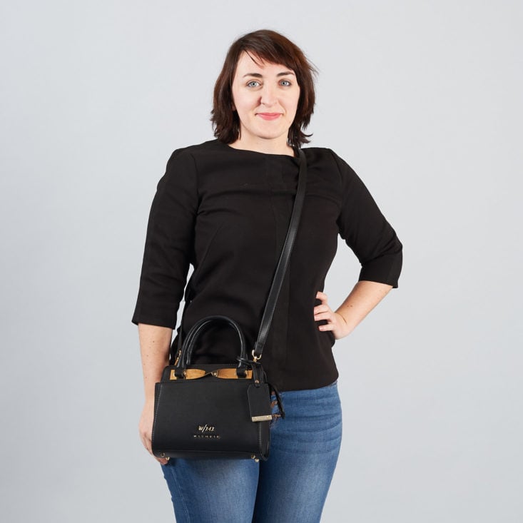 woman wearing a black handbag with a shoulder strap