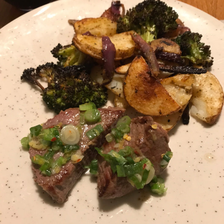 close up of beef medallions and scallion salsa verde with potatoes and broccoli. plated