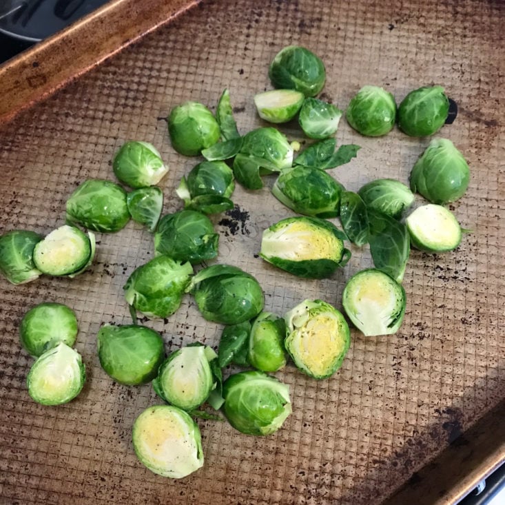 halves brussels sprouts on baking sheet with olive oil, salt, and pepper
