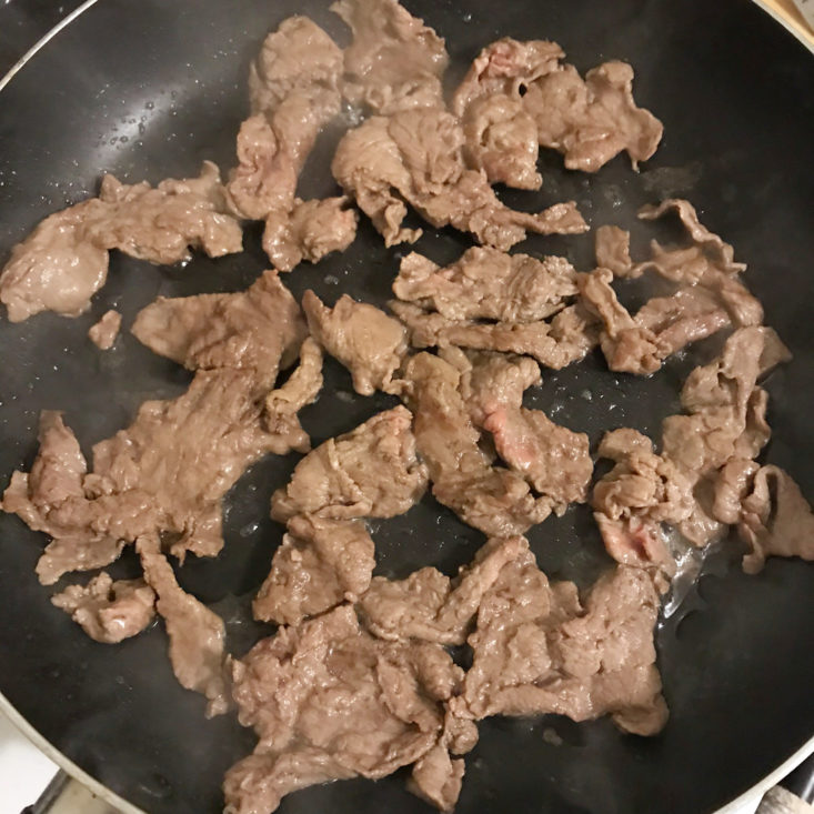 steak strips cooking in pan