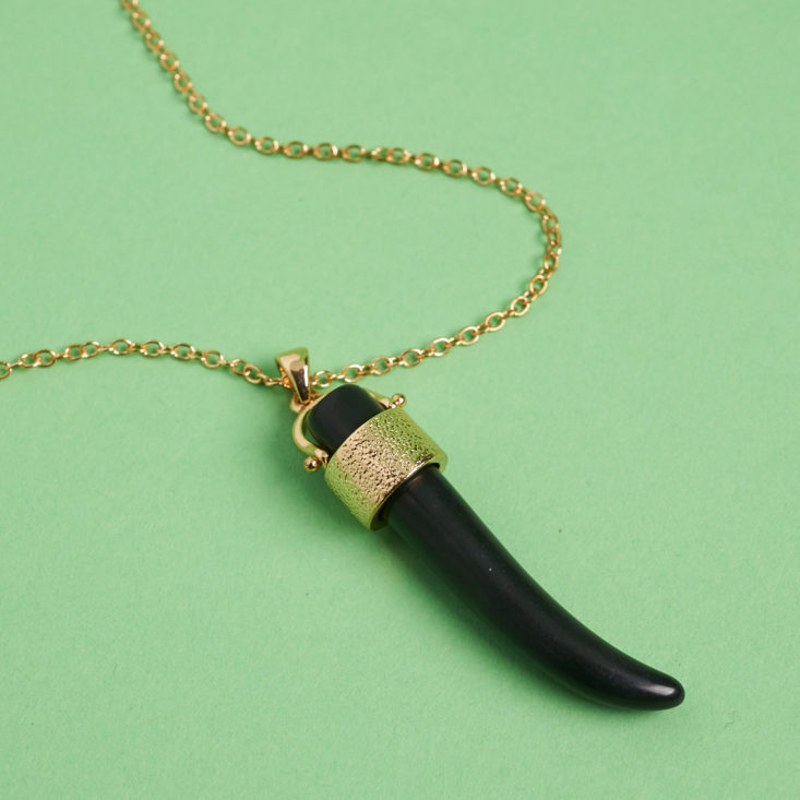 black pendant on long necklace