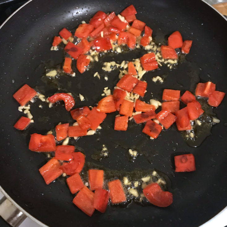 garlic added to red peppers in pan