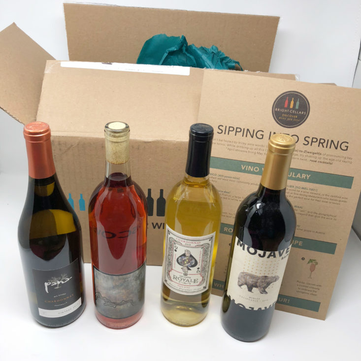 Four bottles of wine in front of the Bright Cellars open box