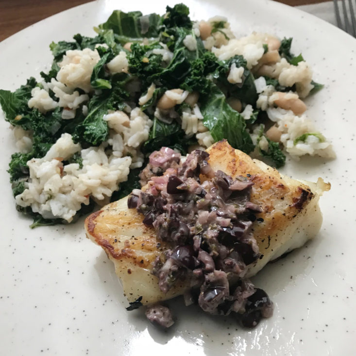 close up of finished Seared Cod and Olive Tapenade with kale and brown rice
