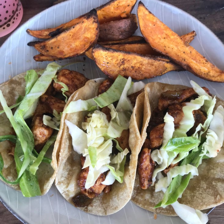 close up of finished BBQ chicken tacos with cabbage slaw and roasted sweet potatoes