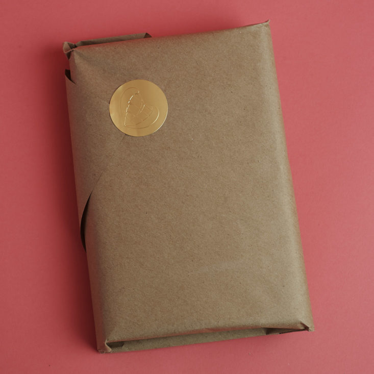 package wrapped in kraft paper with gold seal