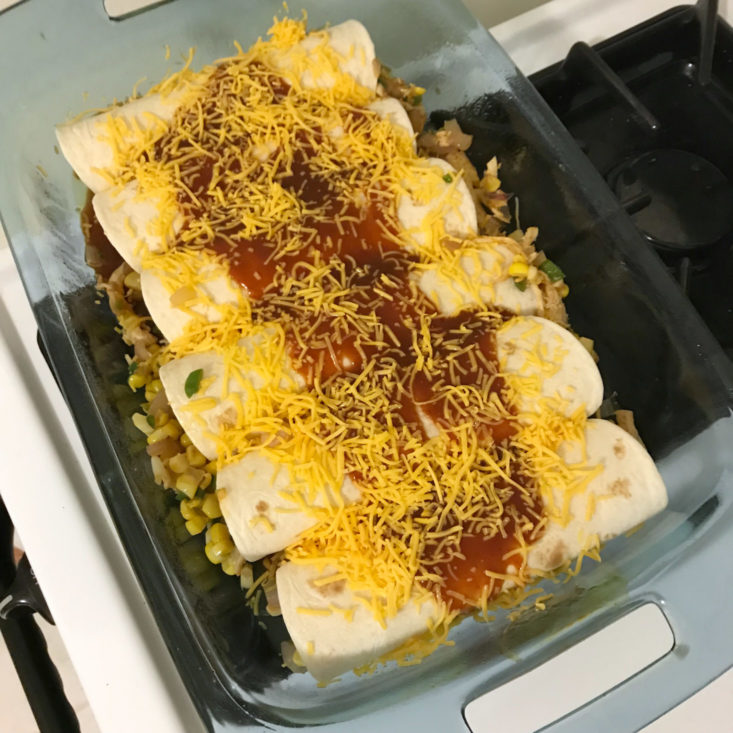 cheese and sauce on top of enchiladas in pan