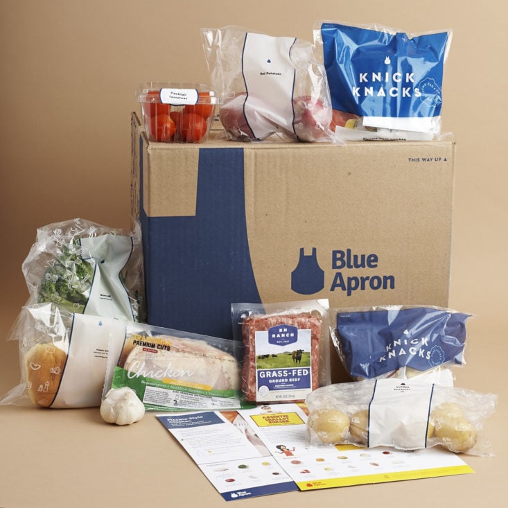 Blue Apron meal kit subscription shown with all its contents displayed around it.
