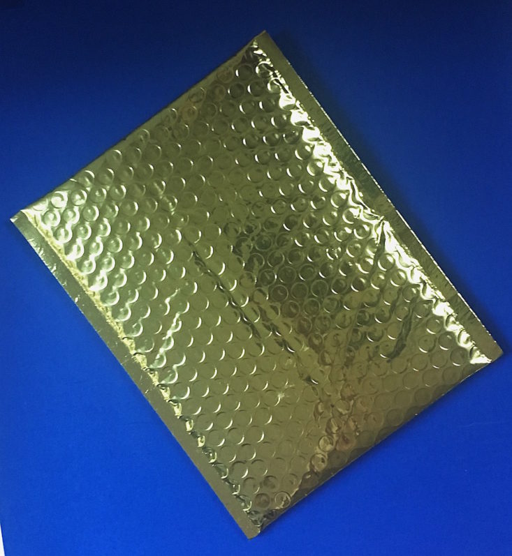 gold bubble mailer laying on a blue background