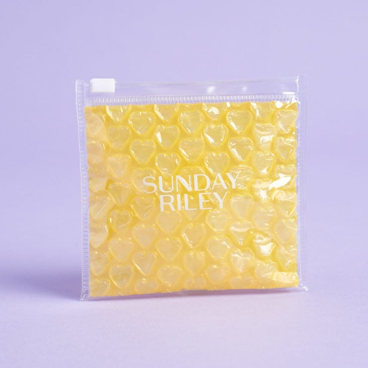 Yellow Sunday Riley pouch, upright