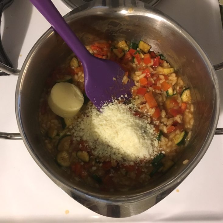 mixing in parmesan and butter with the veggies and rice