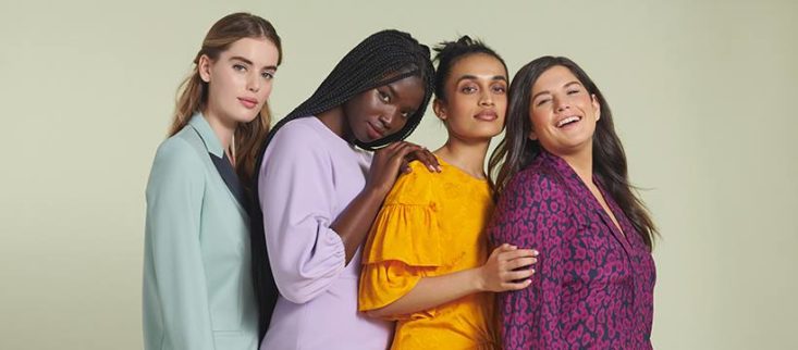 four women of different sizes in colorful rent the runway looks