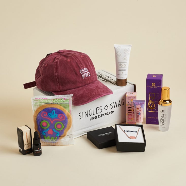 SinglesSwag box with contents, which include Good Vibes Hat, sugar cookie, necklace, and body items