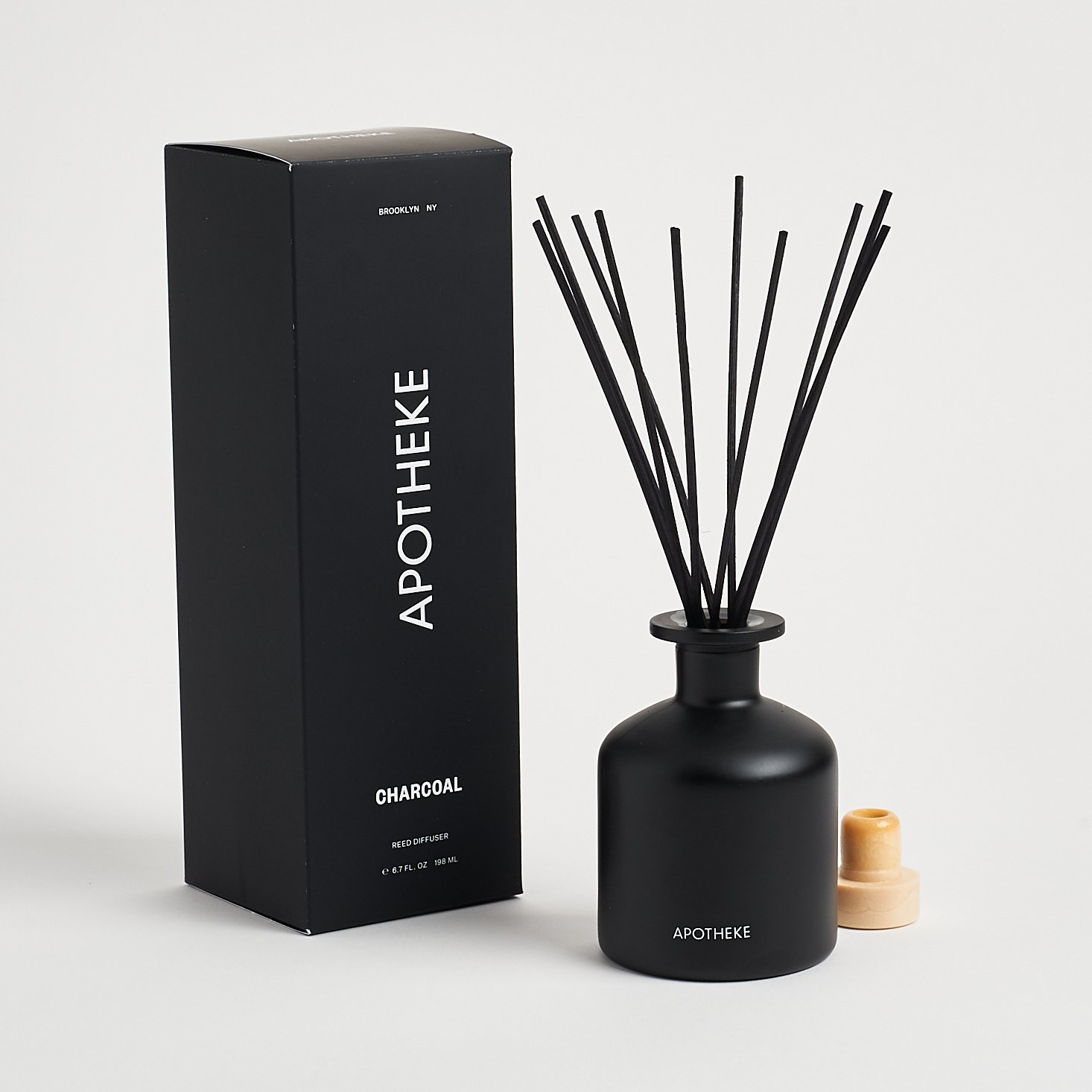 Apotheke Charcoal Diffuser with reeds in, next to box